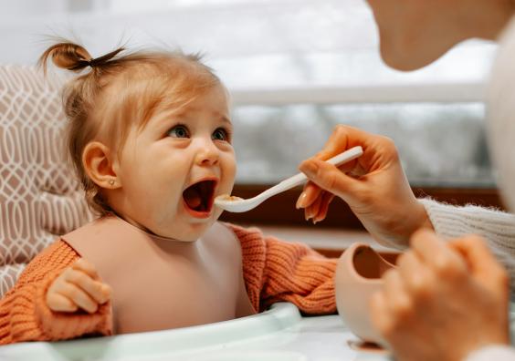woman feeding a baby with a spoon