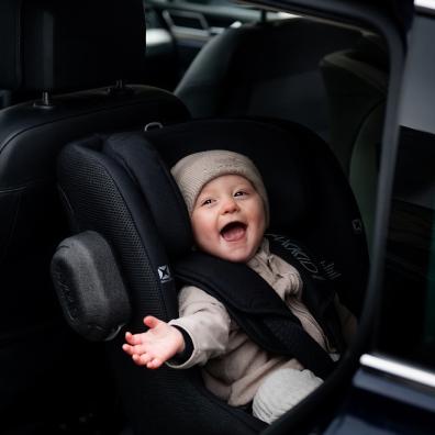 picture of a happy baby in a Axkid Minikid rear facing car seat