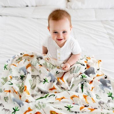 picture of a happy baby sitting under an animal themed Loulou Lollipop blanket