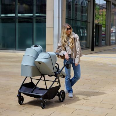 picture of a mum using a Ickle Bubba Altair Double Pram in a city centre out shopping