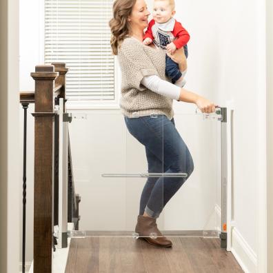 picture of a mum using a fred safety screw fit clear view stairgate