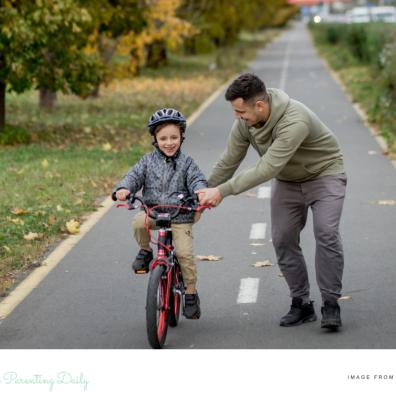 a dad teaching his child how to ride a bike in the winter picture of a dad teaching his child how to ride a bike in the winter