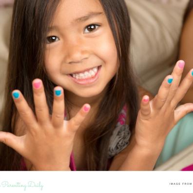 a happy child showing off her nails that are painted with non toxic colourful polish picture of a happy child showing off her nails that are painted with non toxic colourful polish