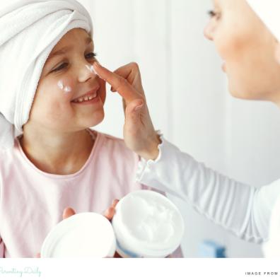 a happy child who suffers from dry skin having lotion put on her face picture of a happy child who suffers from dry skin having lotion put on her face