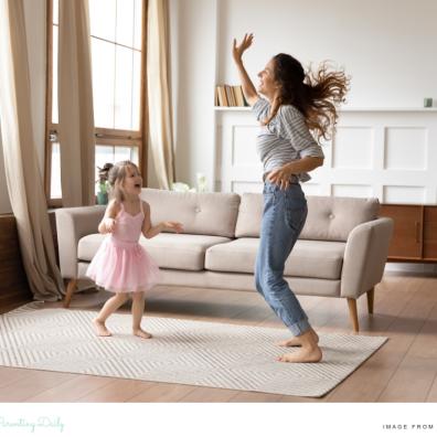 picture of a happy healthy mum dancing with her daughter in the living room