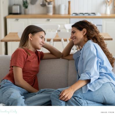 picture of a happy parent sat on a sofa talking to her teenage daughter