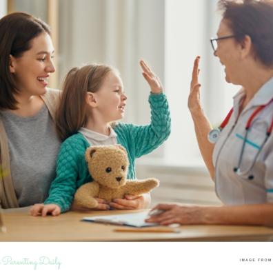 picture of a mum and daughter with a doctor the girl is high fiving the doctor