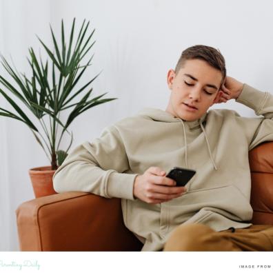 picture of a teenage boy who is looking at Youtube mental health shelves on his smart phone