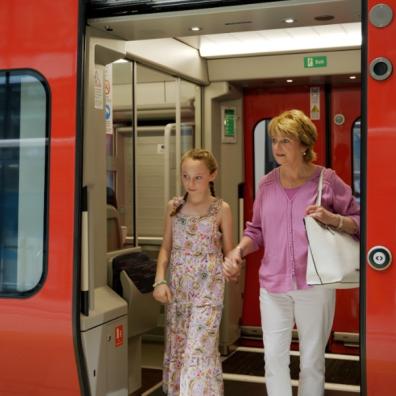 picture of a Grandparent and child getting off a train