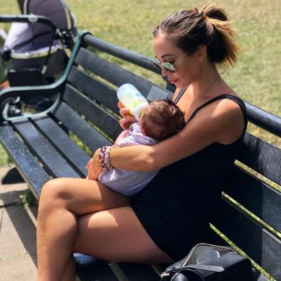 picture of lauren goodger feeding her baby outside on a bench