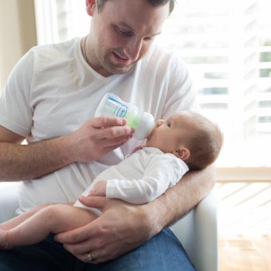 picture of a dad bottle feeding a baby with a dr browns bottle
