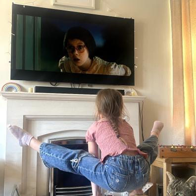 picture of a child doing gymnastics moves on handstand blocks in front of the tv