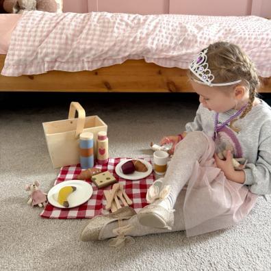 picture of a child playing imaginatively with a wooden tea set in a beautiful bedroom