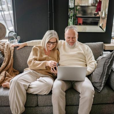 picture of a happy retired couple looking at a laptop