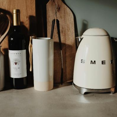 picture of a kitchen side with a kettle bottle of wine and utensils