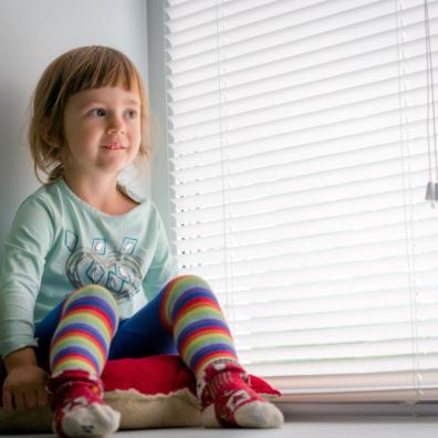 picture of Toddler sat next to window blinds