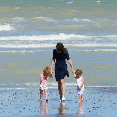 picture of a mum and her two children on a beach holday