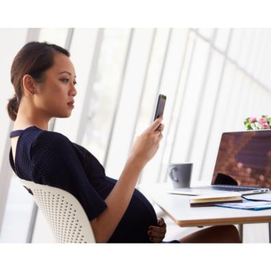 Picture of a pregnant woman reading a text message on her smart phone