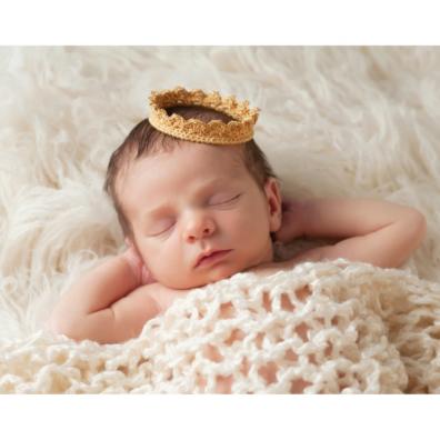 Photo of a newborn baby wearing a crown