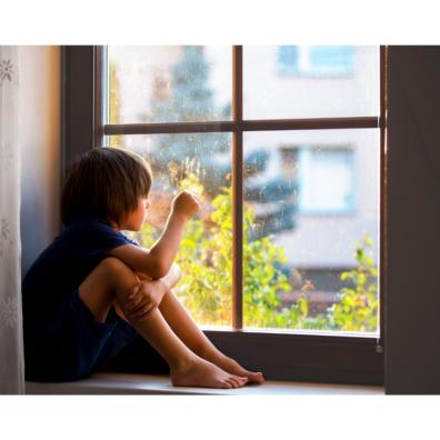 Picture of child sat looking out of a window