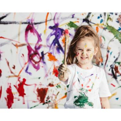 Picture of a child making a mess painting on a wall