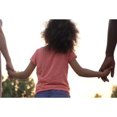 Picture of adopted child holding hands with parents