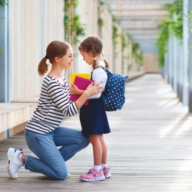 Picture of a child with her mum on her first day of school