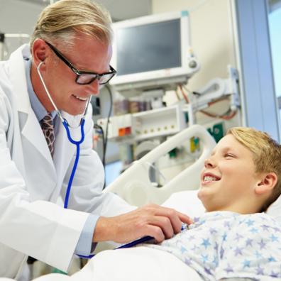 Picture of a child in a hospital bed being seen by a doctor