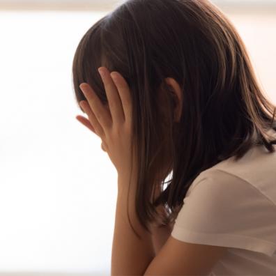 Picture of a sad child with her head in her hands