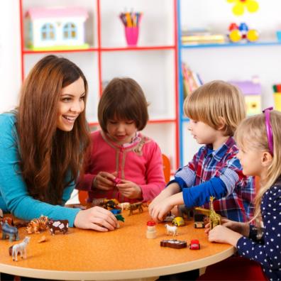 picture of nursery children and their nursery teacher playing with toy animals