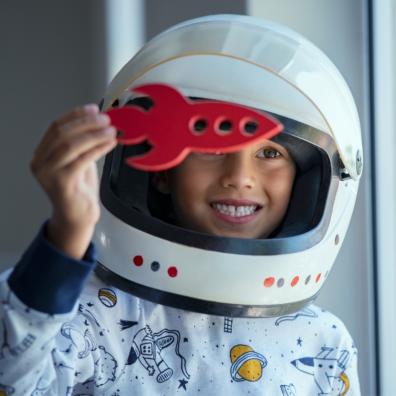 picture of a child dresses as a astronaut holding a toy rocket