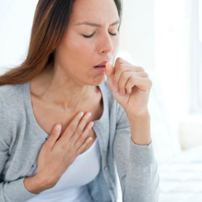 picture of an unwell woman coughing into her hand