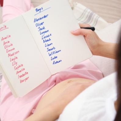 picture of a pregnant woman writing a list of baby names