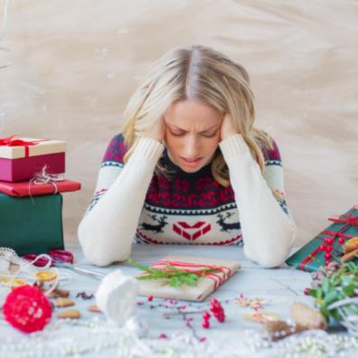 picture of a woman looking stressed wrapping christmas presents
