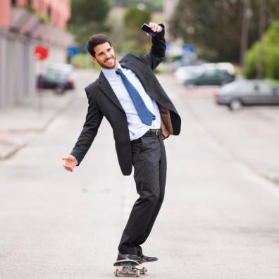 picture of a middle aged man in a suit skateboarding