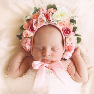 picture of a baby in pink with a floral head band