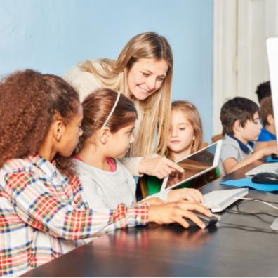 picture of teacher with pupils on computers