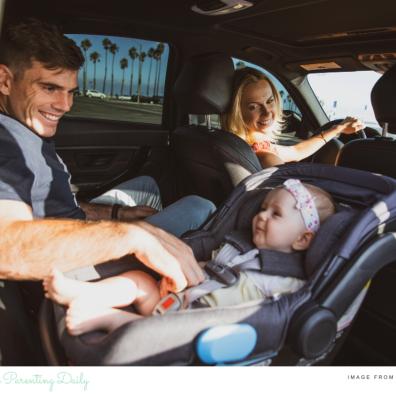 picture of a baby in a rear facing car seat with mum and dad