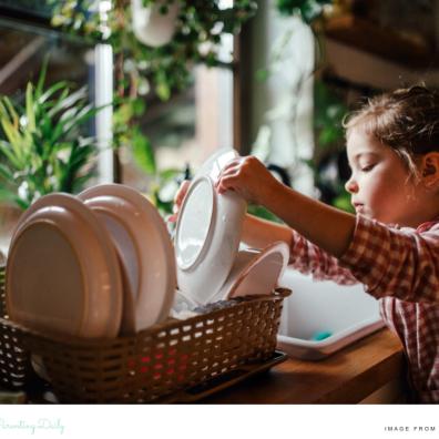 picture of a child learning independence through household chores like doing the dishes