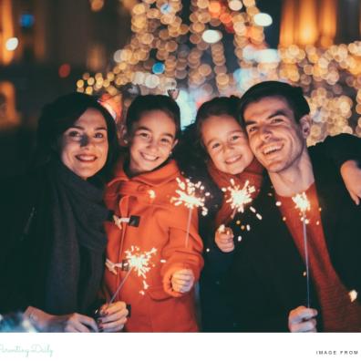 picture of a happy family holding sparklers celebrating New Years Eve together