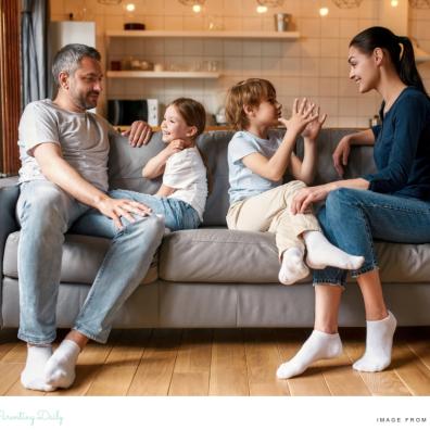 picture of a happy family sat on a sofa talking to eachother building good communication skills