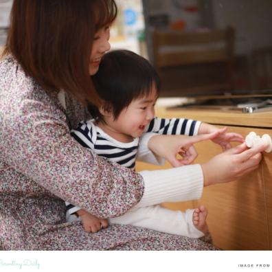 picture of a mum and baby putting cupboard locks on to childproof their home