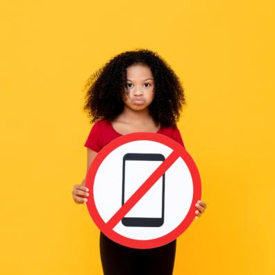 picture of a child holding a sign saying mobile phones are banned