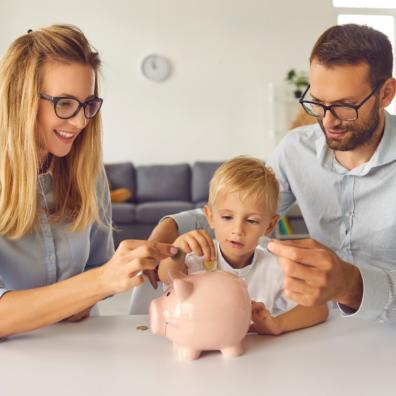 picture of a child putting money into a piggy bank