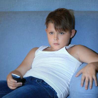 picture of a child sat on a sofa watching television