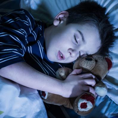 picture of a child sleeping with a teddy bear