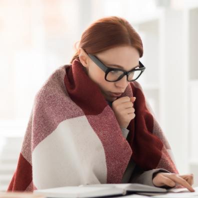 picture of a cold woman working in a blanket