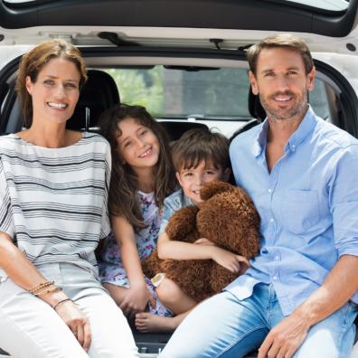 picture of family sitting in the boot of their car