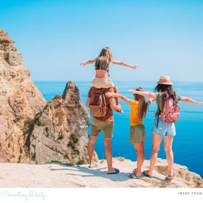 picture of a family stood on a cliff top looking out at the sea