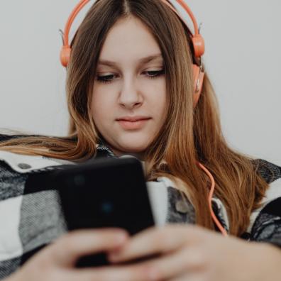 picture of a girl on her mobile phone with headphones on